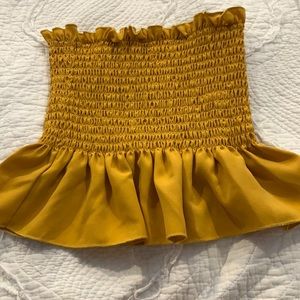 Mustard yellow tube top ruffles at the bottom.